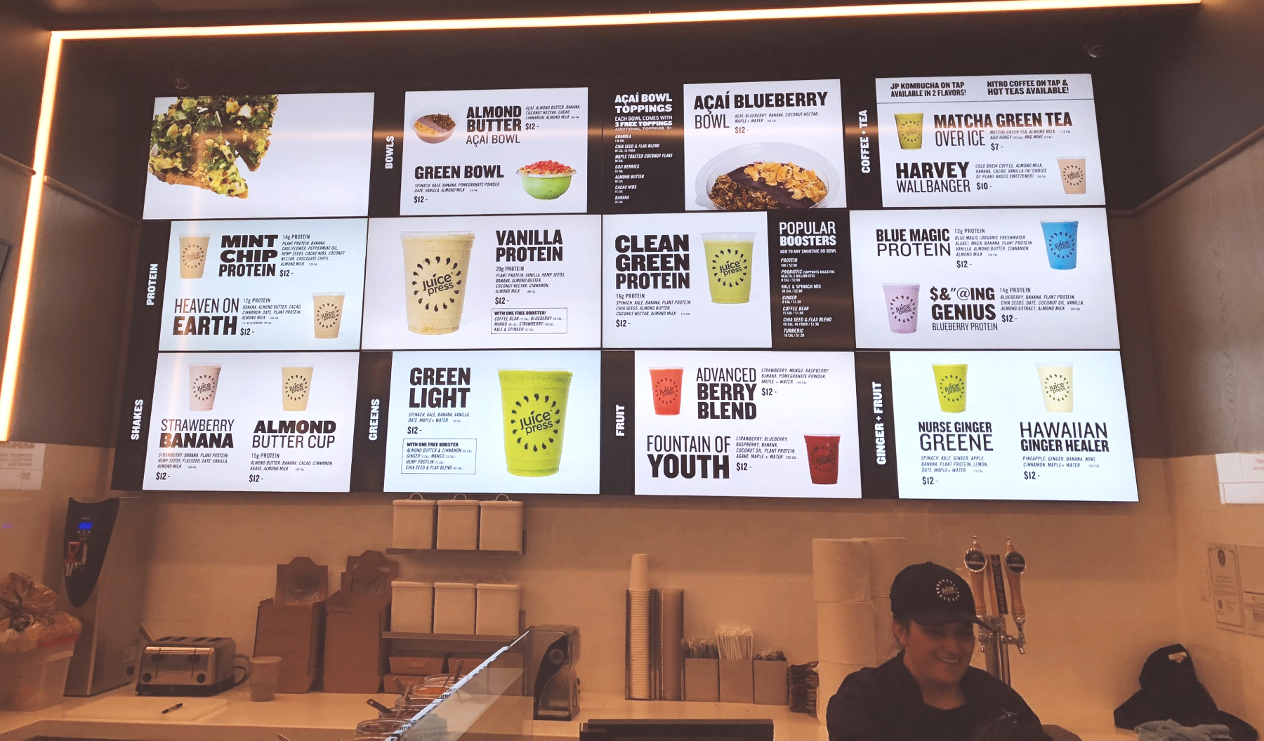 Grid-style digital menu wall above a service counter